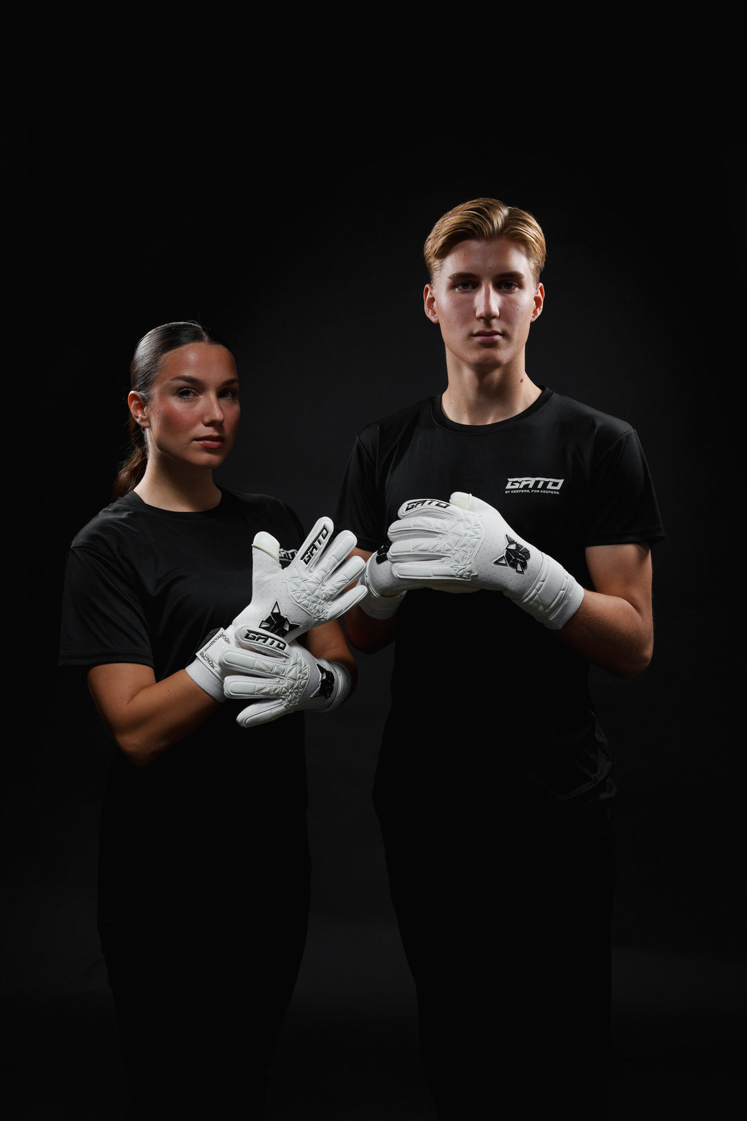 White GATO goalkeeper gloves on artificial grass