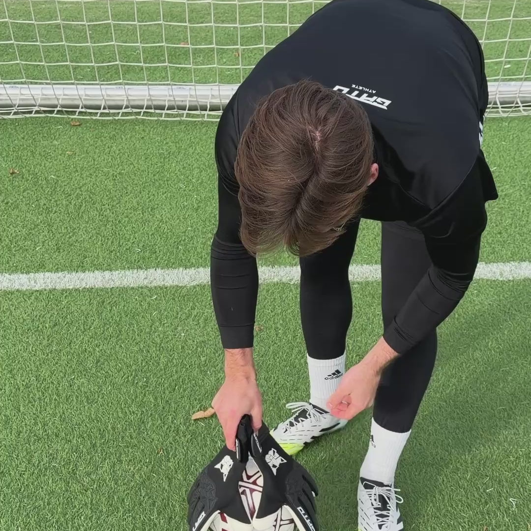 Goalkeeper taking black GATO Classic Training goalkeeper gloves out of the glove bag and catching a ball